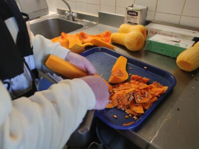 Photo d’une bénévole qui prépare des produits locaux pour les cuisiner et les mettre en vente dans l’un des caisses alimentaires.